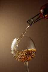 Pouring white wine from a bottle into a glass.