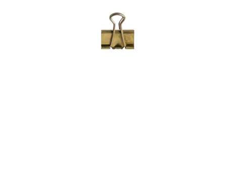 A single brass binder clip, partially illuminated, floats against a deep, uniform black background