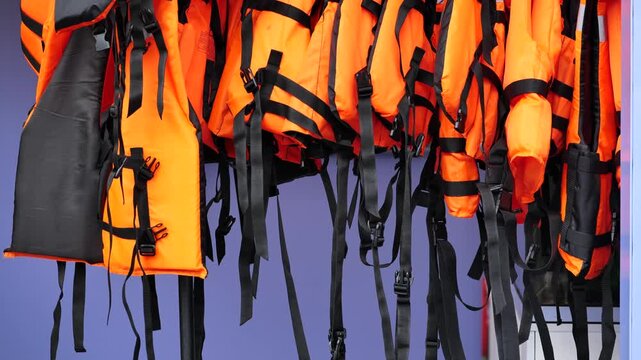 Orange life jackets hanging, providing essential water safety and protection.