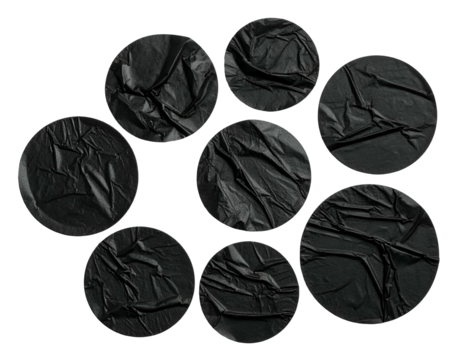 Composition of circular, wrinkled black fabric patches against a black background