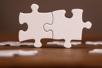 Two jigsaw puzzle pieces fitting together, representing teamwork, solutions, and connection. Symbolizing completing a task, finding answers, or