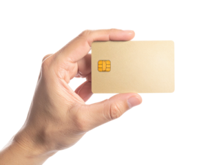 A human hand holds a blank, gold-colored card with an embedded chip against black