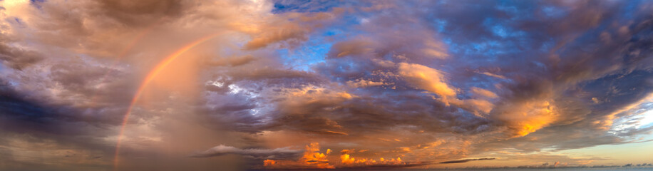 Dramatic sunset sky covered with colorful yellow clouds. Panoramic skyscape
