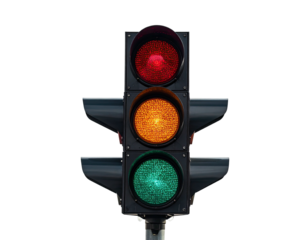 A traffic light, red, yellow, and green, against a stark black background