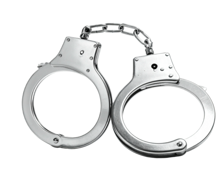 Metallic restraining devices, connected by a chain, against a stark black background