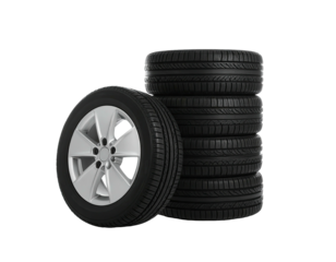 A stack of black rubber tires with a silver wheel against a stark black background