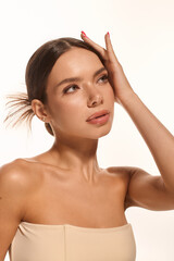 Beautiful young woman showcasing natural beauty against a soft white background