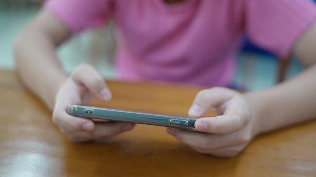 Closeup girl hands using smartphone to text the message or playing online game on her phone. Concept of digital addiction. Digitalization and informatization of society in modern world.