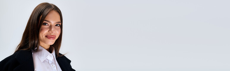 Young woman showcases autumn style in a stylish outfit within a grey studio space