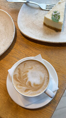 Closeup Of Cup Of Cappuccino With Leaf Latte Art On Wooden Table In Cozy Cafe Creating Autumn Coffeehouse Atmosphere.