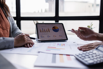 Business team using calculator and laptop for do math finance on wooden desk in office and business working background, tax, accounting, statistics and analytical research concept

