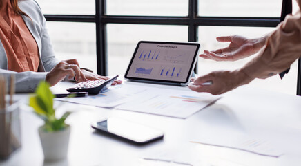 Business and Financial Planning Concept. Financial advisor hand planning and calculate budget, and tax. Professional Businesswoman use calculator and review annual report at office.
