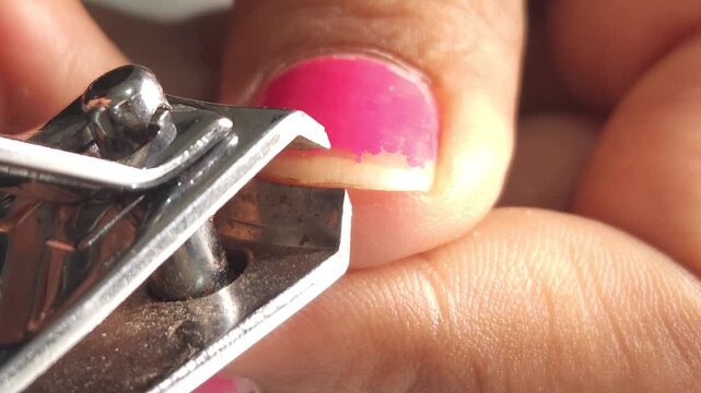 Using nail cutters to trim fingernails close up.