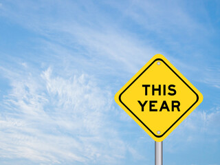 Naklejka premium Yellow transportation sign with word this year on blue color sky background