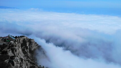 White clouds flowing over rocky mountain peak. Media