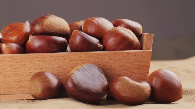 Fresh chestnut, supermarket food, Oven roasted chestnuts with sliced peel on wooden board, spanish traditional winter dish.
