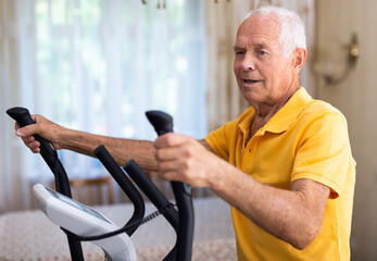 Male is working out on elliptical machine for elder healthy concept