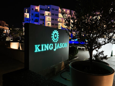 Neon King Jason sign at night outside a modern hotel with glowing blue and green lights in Protaras, Cyprus.