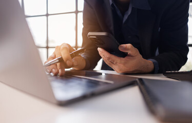 Business man pen in hand and mobile phone, online working at office. Student studying online, surfing the internet, searching the information, e-learning, business technology
