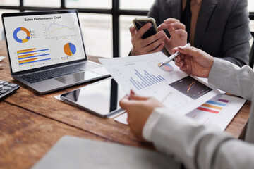 Business team holding pen colleagues reviewing financial data and discussing investment strategies
