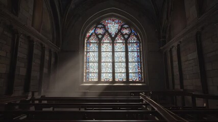 Sunlight streaming through stained glass windows in serene cathedral interior. 4k Video footage - Powered by Adobe