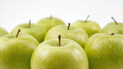 Detailed view of vibrant green apples on a white backdrop, ideal for promoting healthy diets.
