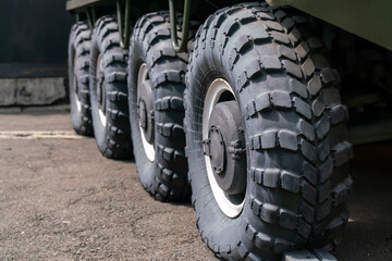 Four large black wheels of an armored vehicle with increased cross-country ability.