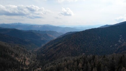 Clouds passing over a mountain valley with forest. Media