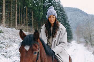 Fototapeta premium Stylish young woman with horse in snowy forest Generative AI