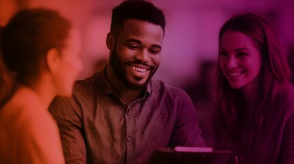 A diverse group of colleagues smiling and actively collaborating around a digital tablet during a positive business meeting