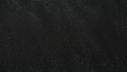 Close-up shot of dark volcanic sand grains with detailed texture