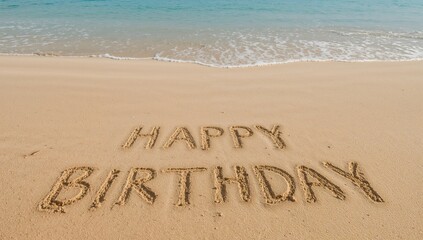 Fototapeta premium Birthday greetings spelled out in the sand by the seaside.