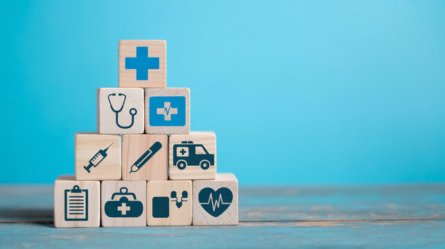Healthcare icons on wooden blocks stacked against a blue background