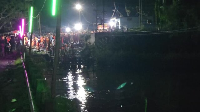 Authentic nighttime footage of Kanwariya devotees offering prayers during a rest stop on the sacred Kanwar Yatra in the holy month of Shravan (Sawan), India. Dressed in traditional saffron attire