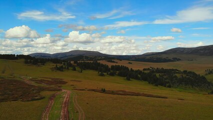 Aerial view flying over green rolling hills. Media