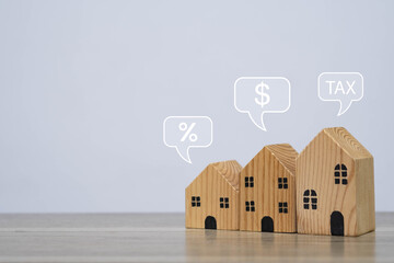 Wooden houses with tax, percentage, and dollar icons represent real estate investment, property tax planning, mortgage interest rates, and home finance management concept.