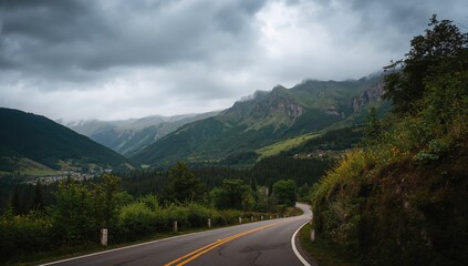 Naklejka premium Stunning picture of a highway leading towards peaks beneath a cloudy sky