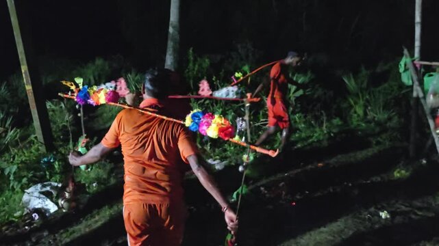 Authentic nighttime footage of Kanwariya devotees Dressed in traditional saffron clothing, the devotees carry holy water to perform Jalabhishek at Lord Shiva temples. This documentary-style footage