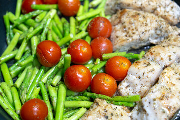 Close-up, Red Snapper Steak, Asparagus, and Tomatoes in a Iron Pan.