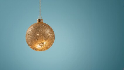 Festive season photo featuring a golden ornament suspended mid-air against a blue backdrop