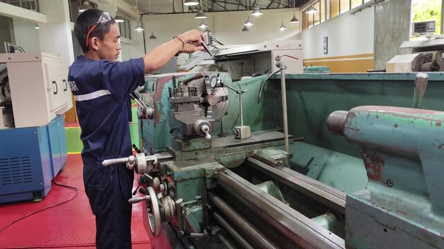 Makassar, Maret 21, 2024 -A machinist working with a metal lathe in a workshop, focusing on precision machining process under bright industrial lighting.
