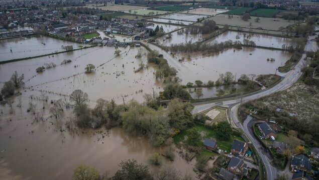 Drone aerial view of flooded farmland and farmhouse caused by major river flooding following a storm