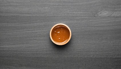 Tasty honey jar on a gray surface, seen from above with space for text