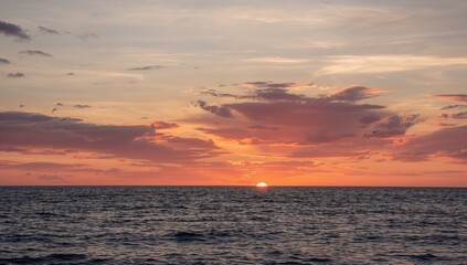 Naklejka premium Sunset with intense clouds above the ocean