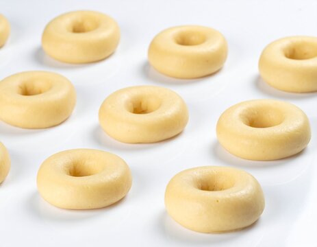 Raw Donut Dough Rings Arranged on White Background