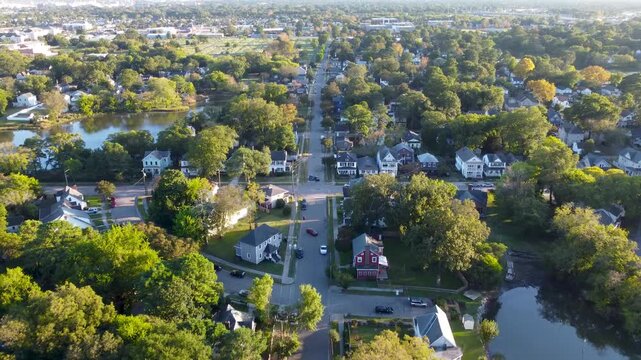 Norfolk, Virginia aerial cinematic video at sunset showing boats docked along the waterfront and a calm river surrounded by neighborhoods and trees.