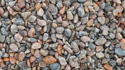 Vibrant pebbles decorating the shore, each with a distinct shape and smoothed by ocean tides. These eye-catching stones in hues of pink, blue, and natural earth colors form a beautiful organic