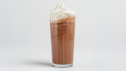 Chocolate milkshake topped with whipped cream in a glass against a white backdrop