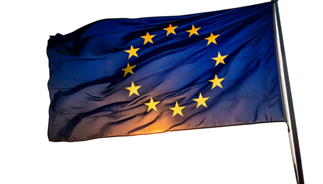 The flag of the european union, with its circle of stars, waving against a sunset white