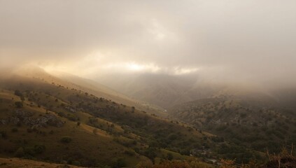 Fototapeta premium A picturesque landscape of fog-covered hills